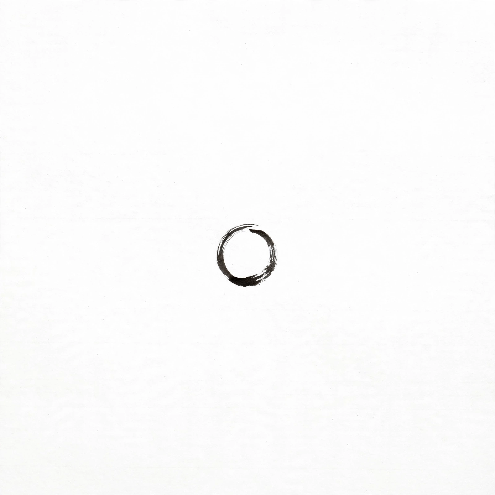 A single black enso circle brushed on white
