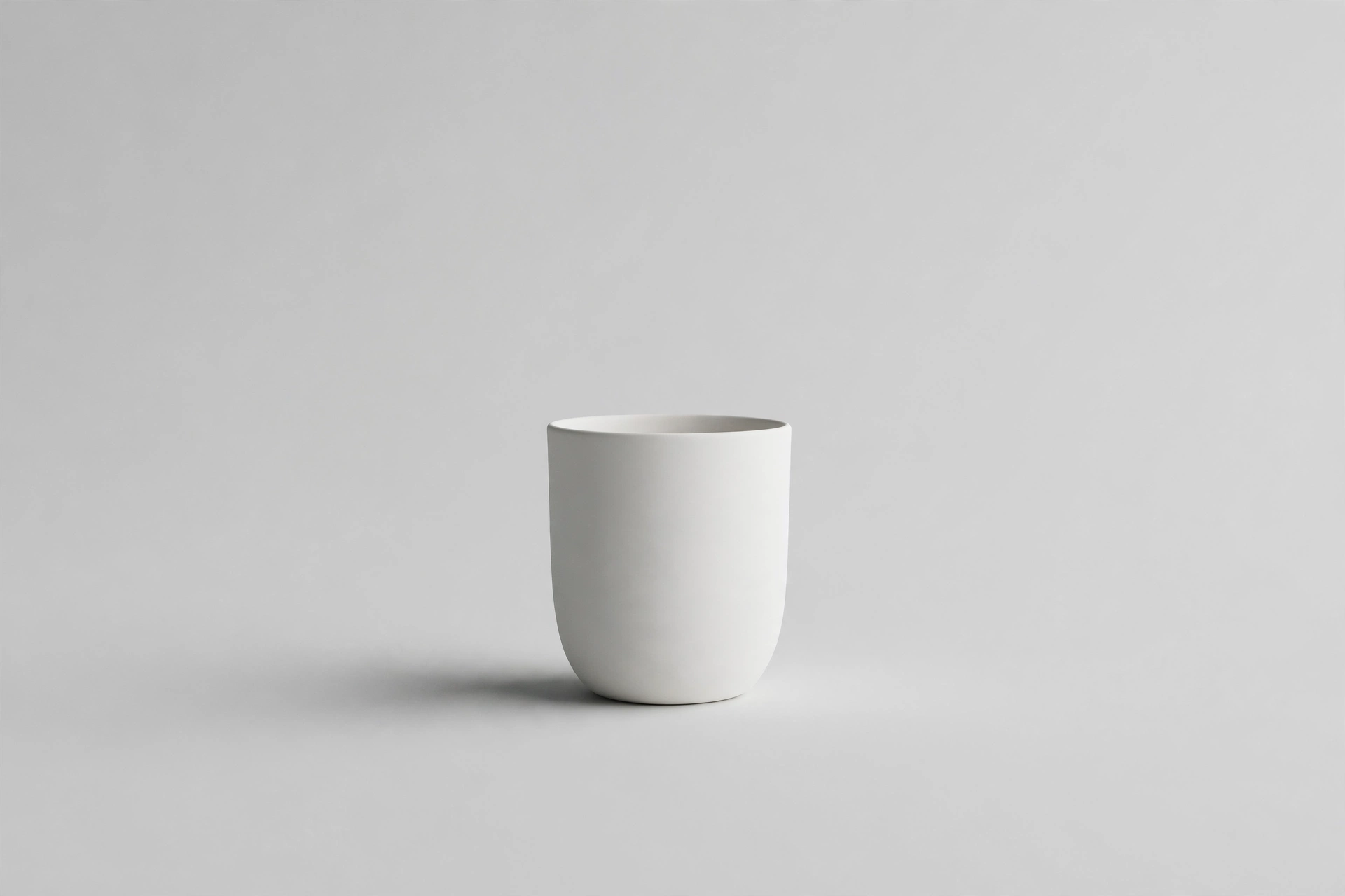 A single white ceramic vessel on a vast empty background, the beauty of removing everything unnecessary